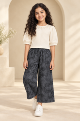 Pakistani girl wearing charcoal trousers with an ivory fusion top