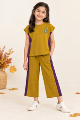 Pakistani girl wearing the mustard and purple co-ord with coordinating ivory sneakers