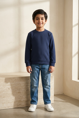 Smiling boy wearing the navy textured sweatshirt with faded blue jeans and white sneakers